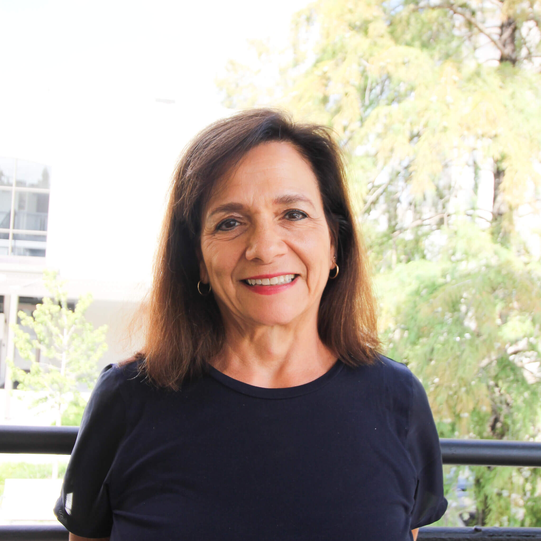 Portrait of a smiling woman in a navy top outdoors